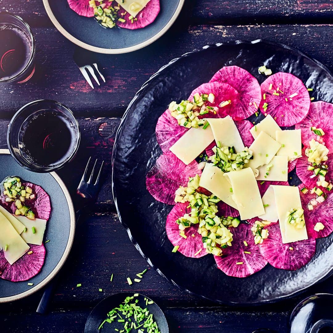 Ob als Vorspeise oder kleiner Snack für Zwischendurch, das rote Rettich-Carpaccio ist nicht nur schön anzusehen. Mit Gouda und einer Gurken- Vinaigrette wird das vegetarische Carpaccio zu einer schönen Kombination, die nach Sommer schmeckt.