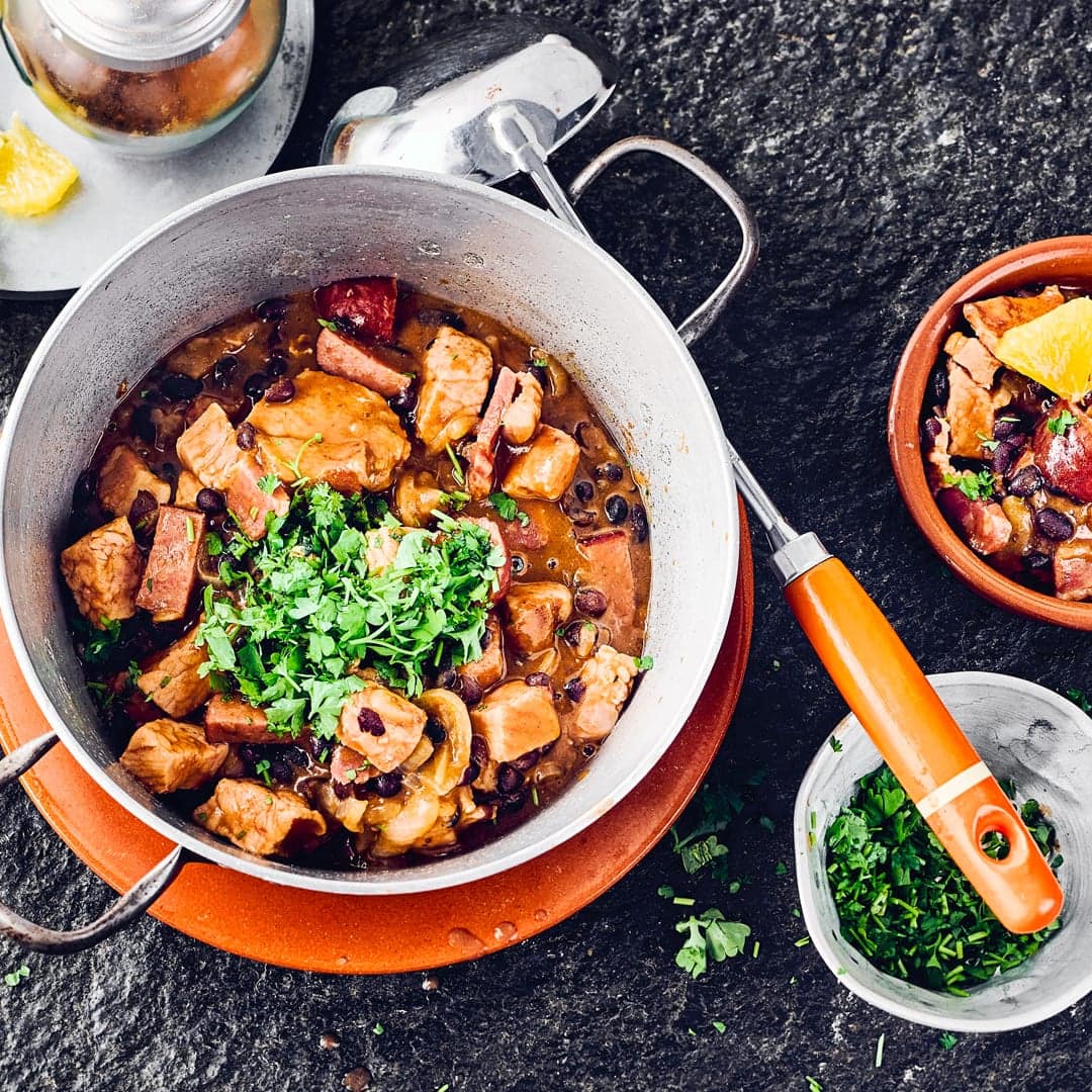 Probieren Sie unser Rezept für eine Feijoada einmal aus: Ein brasilianischer Eintopf mit schwarzen Bohnen, Kasseler, Speck und Cabanossi – herzhaft und lecker!