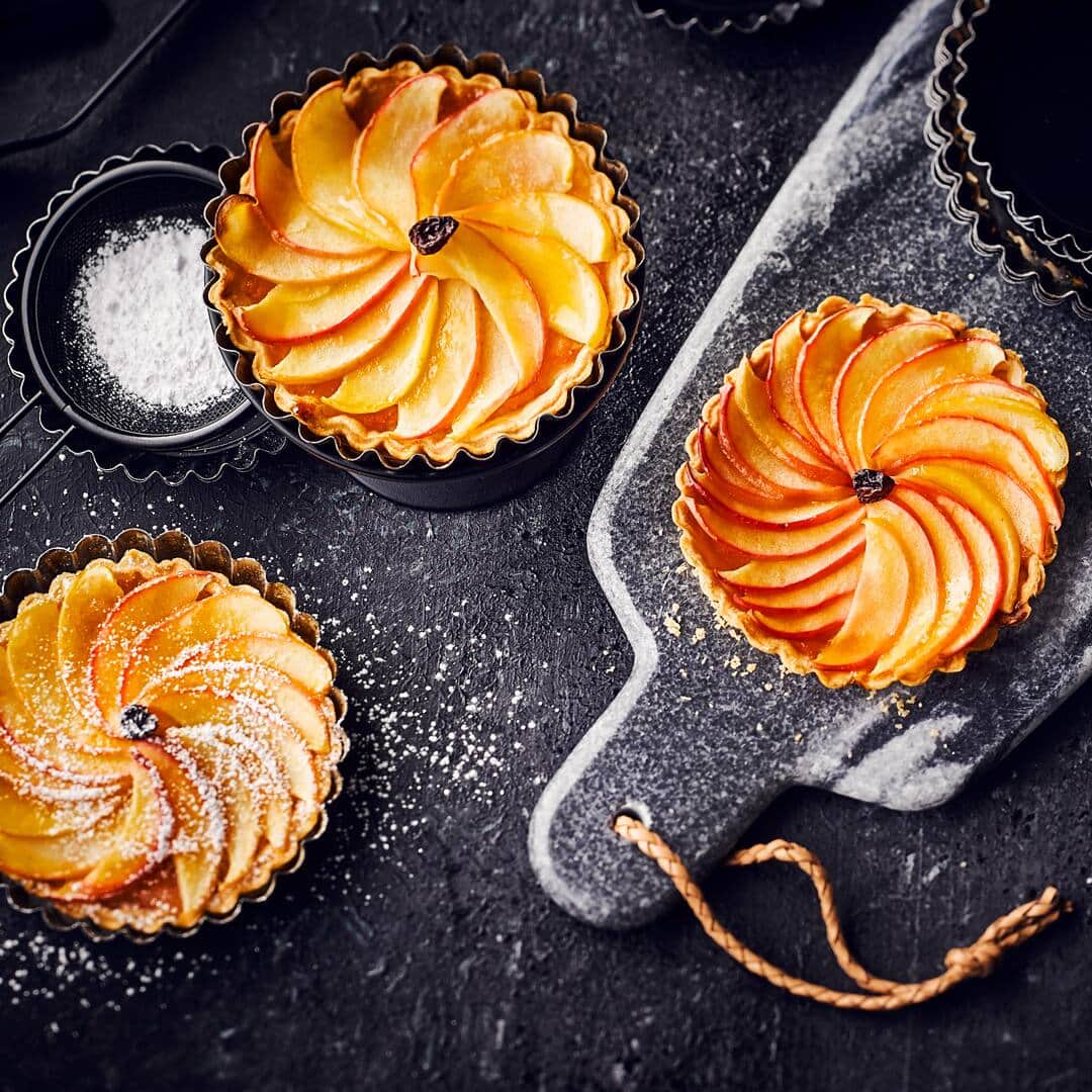Verzaubern Sie Ihre Gäste mit diesem fruchtig-frischen Dessert: Probieren Sie unser Rezept für kleine Apfeltartelettes mit Aprikosenkonfitüre und Korinthen aus – süß und lecker!