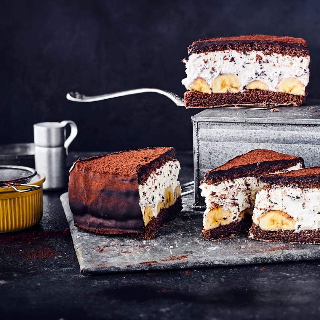 Bananentorte mit Biskuitteig, Sahne-Quark-Frischkäse-Schicht und Schokolade ist nicht nur optisch auf Ihrer Kaffeetafel ein Highlight. Gekühlt schmeckt die Torte am besten!