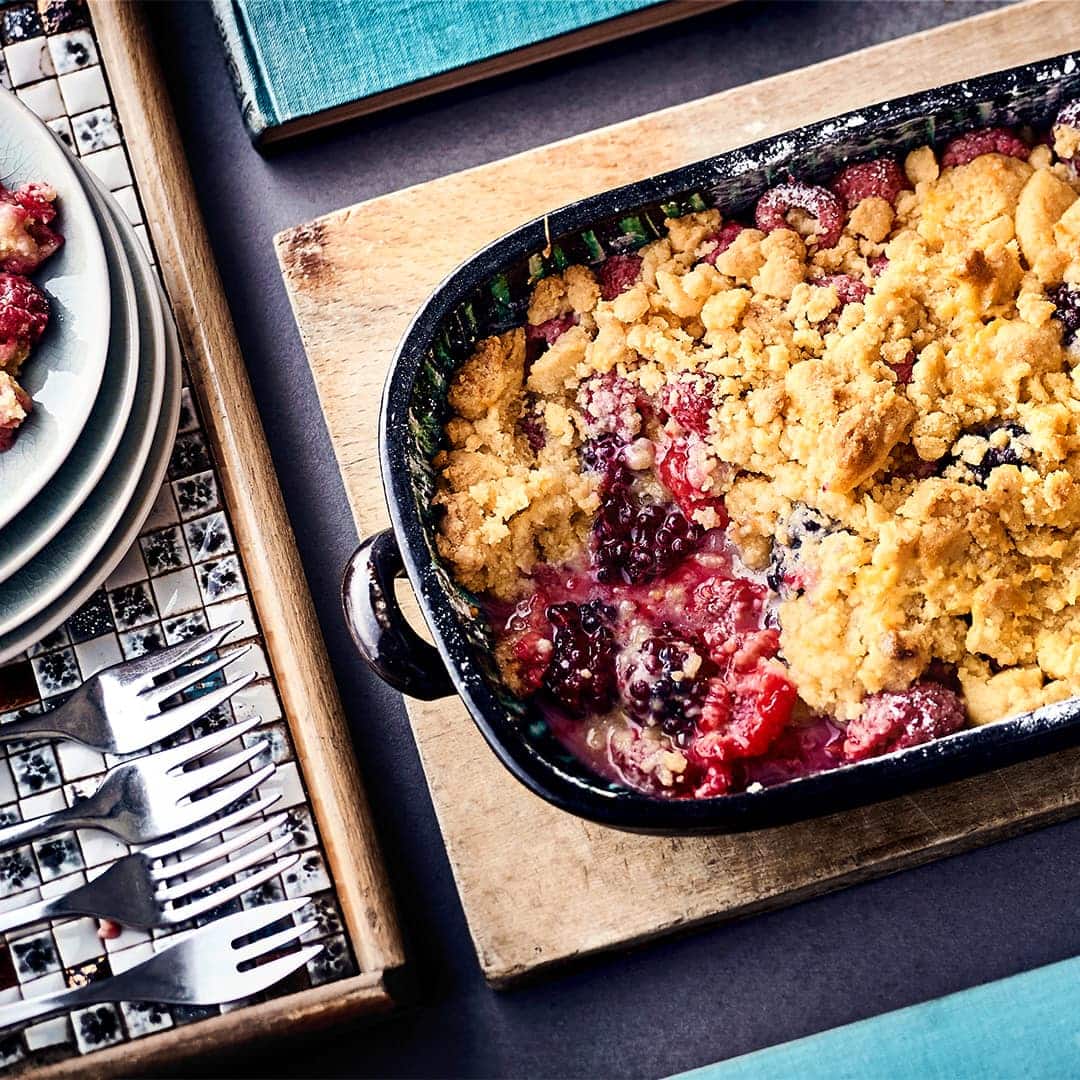 Bei diesem Dessert werden Frucht und Teig "zusammengeflickt": Probieren Sie unseren leckeren Himbeer-Brombeer-Cobbler aus dem Ofen mit Zimt, Puderzucker, Sahnecreme und Crème fraiche!