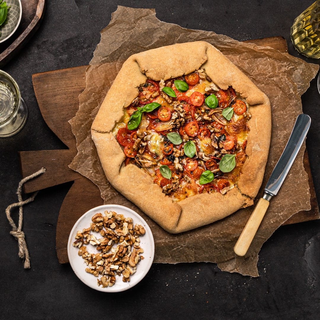 Ein buttriger Mürbeteig, eine Vielfalt an frischen Tomaten, Walnusskerne und Mozzarella ergeben unser Rezept für eine selbstgemachte Tomaten-Galette.