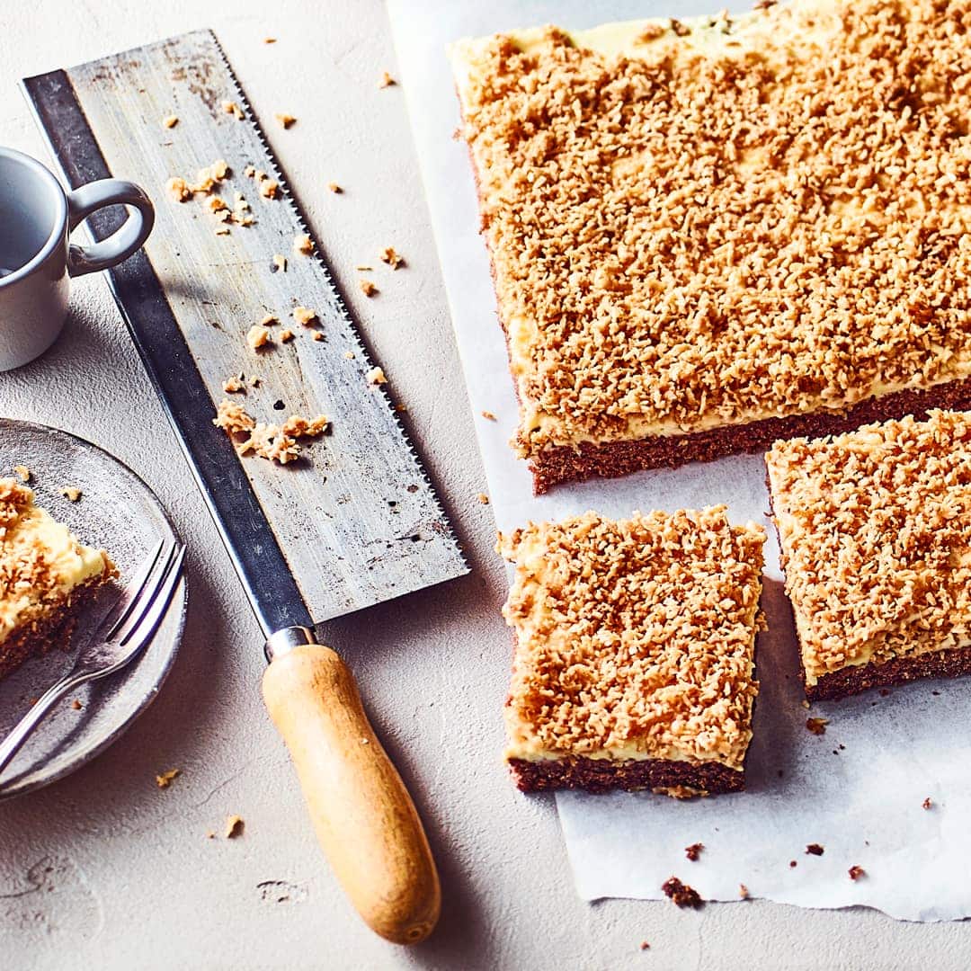 Keine Sorge, den Namen hat dieser super leckere Sägespänekuchen von seinem köstlichen Belag aus Zucker, Butter und Kokosraspeln.