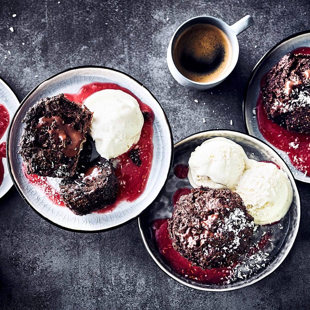 Servieren Sie Ihren Gästen unsere Brownie-Muffins mit Zartbitterschokolade, Bananen & Kardamom an einer fruchtigen Soße aus frischen Himbeeren als Dessert!