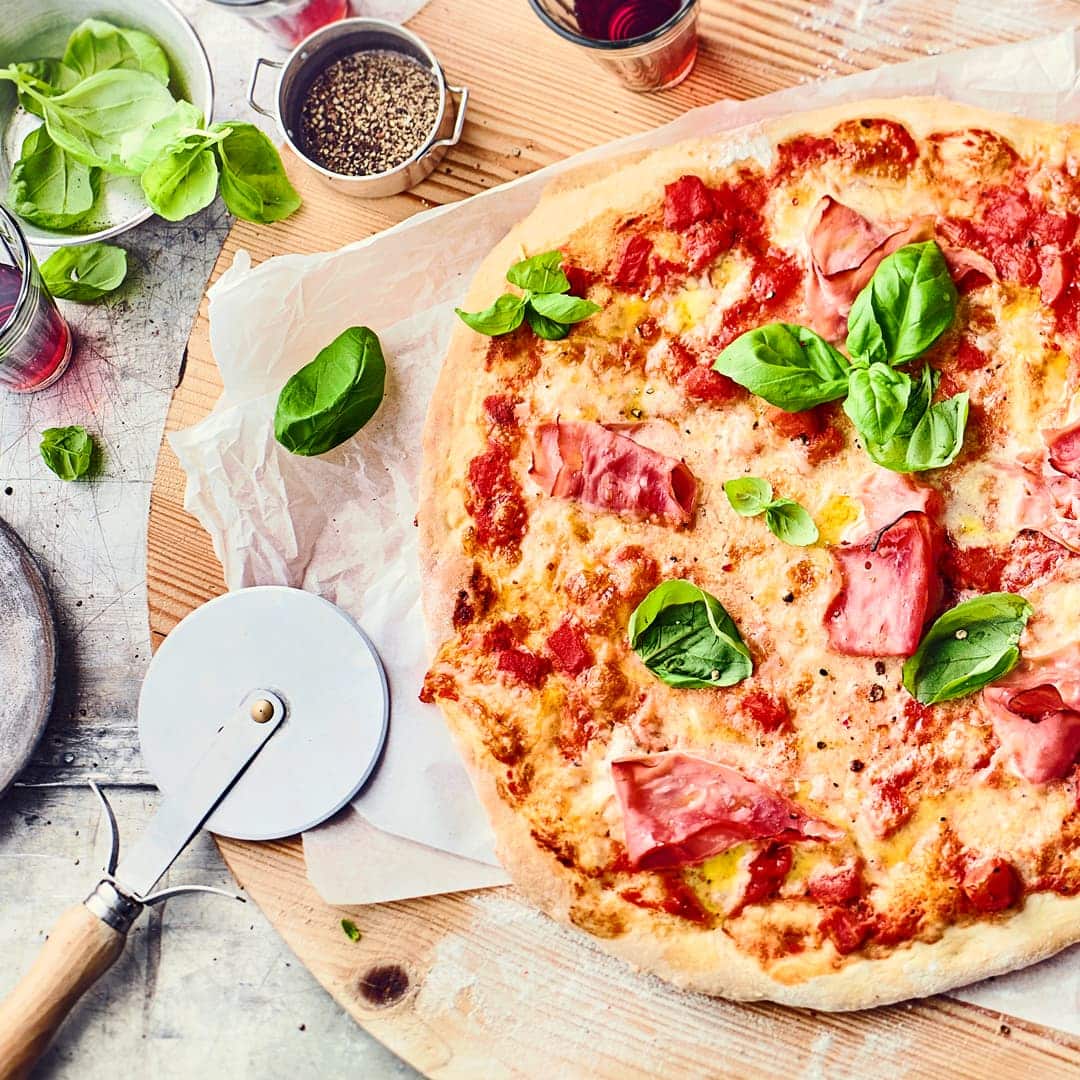 Sicherlich eine Lieblingspizzasorte von Vielen: Pizza Prosciutto mit Tomaten, Prosciutto, Mozzarella und frischem Basilikum.