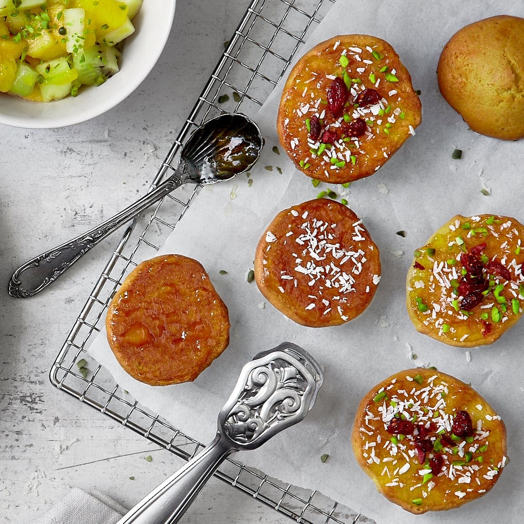 Backen Sie nach unserem Rezept leckere Mini-Amerikaner mit einem Topping aus Kokosflocken, gehackten Pistazien und fruchtigen Cranberrys.