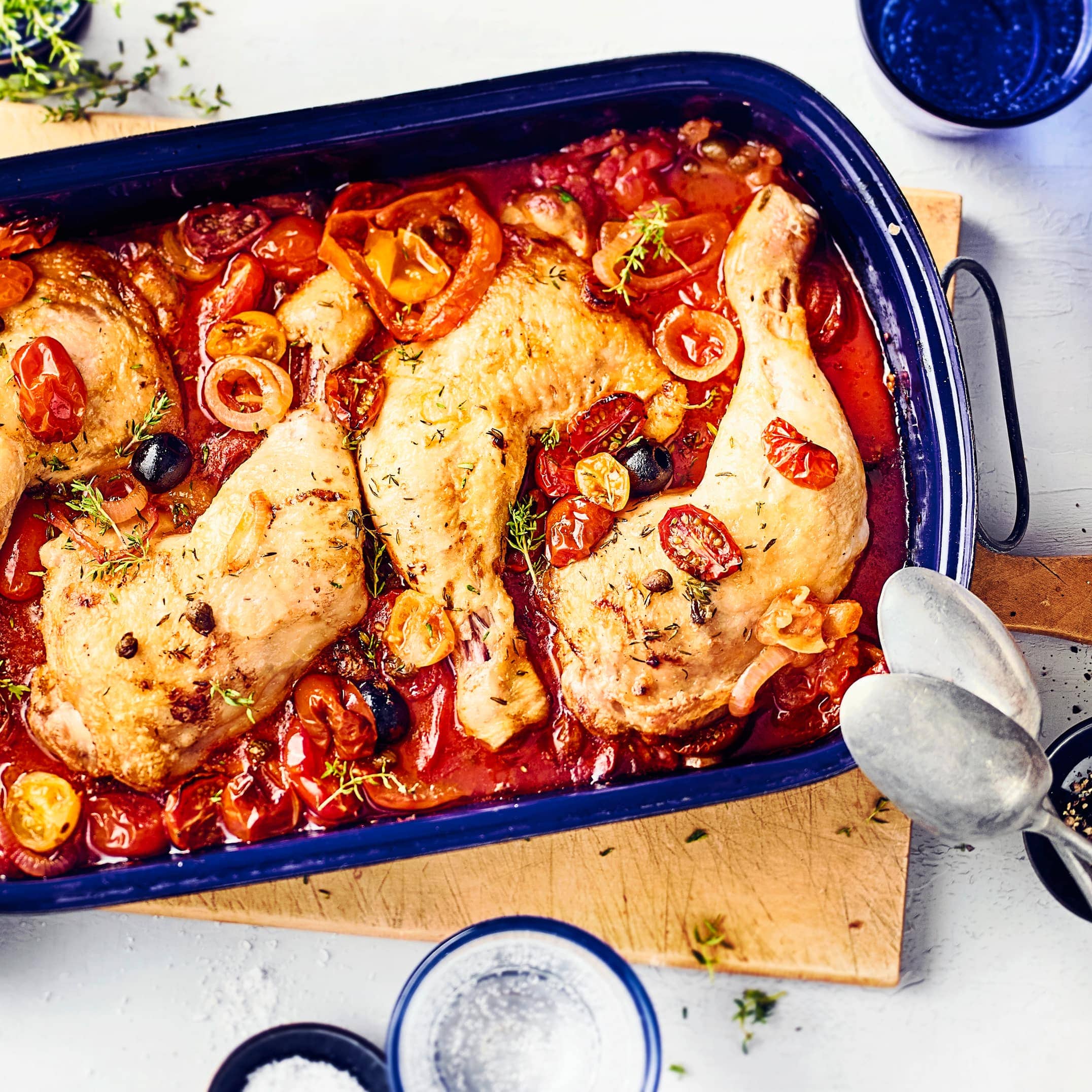 Mediterranes Geflügelgericht aus dem Ofen für Feinschmecker: Probieren Sie unsere geschmorten Hähnchenkeulen mit verschiedenen Tomatensorten, Kapern und schwarzen Oliven!