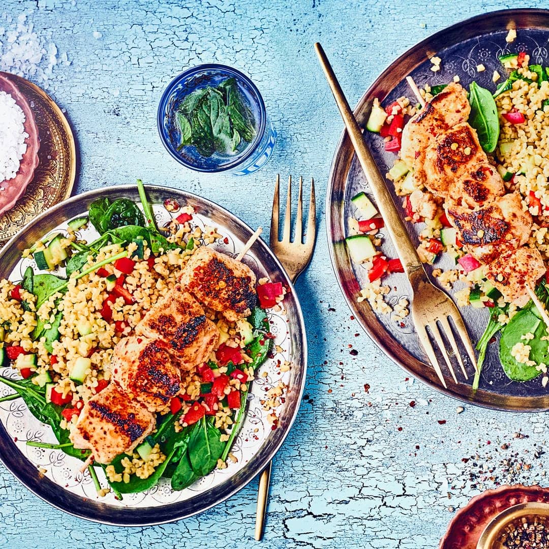 Orientalischer Genuss mit Bulgur: Saftige Hähnchenspieße in einer Honig-Senf-Marinade auf Tabouleh mit knackigem Spinat.