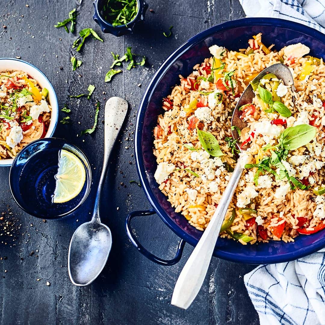 Unser Rezept für eine griechische Reispfanne mit Paprika, Reis, Knoblauch, Thymian und Feta ist komplett vegetarisch und ganz einfach zuzubereiten!
