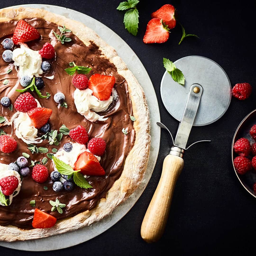 Pizza als Nachtisch – das geht! Mit diesem Rezept gelingt Ihnen eine sündhaft leckere Schokoladenpizza mit frischen Beeren und Minze.