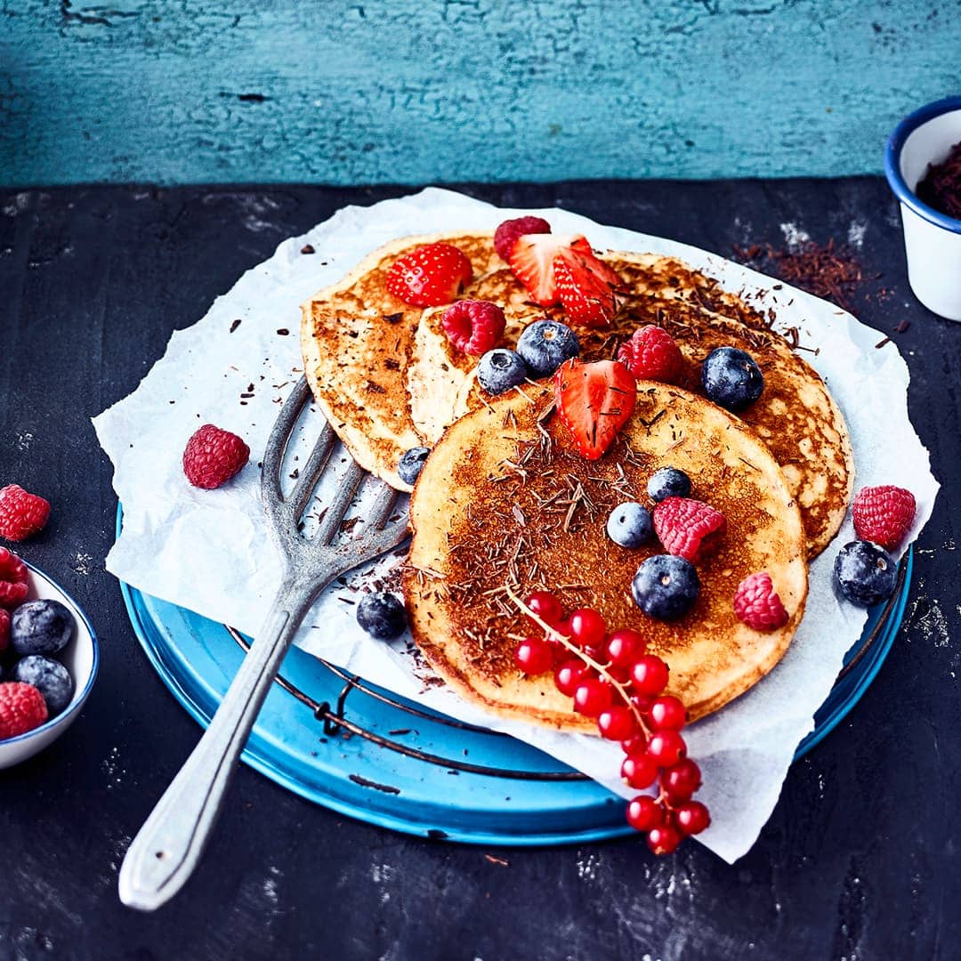 Low Carb und Pancakes – passt das zusammen? Aber natürlich! Unser Rezept für Pancakes braucht kein Mehl, sondern besteht aus Frischkäse, Speisequark, Eiern und gemahlenen Mandeln. Beeren und geraspelte Schokolade runden das Ganze ab.
