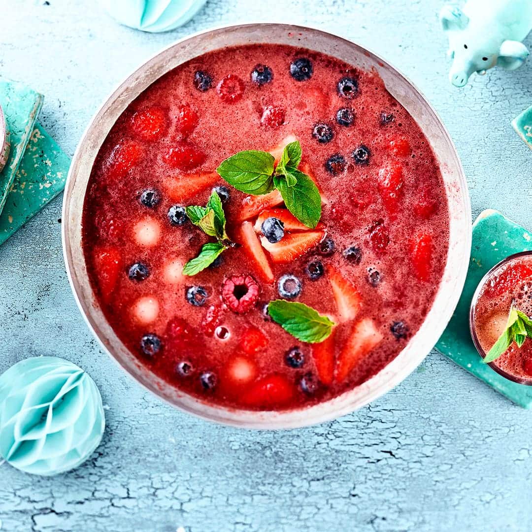Ein Wow-Getränk für die nächste Geburtstagsparty: Selbstgemachte Kinderbowle mit viel frischen Beeren und Pfirsich – super fruchtig!
