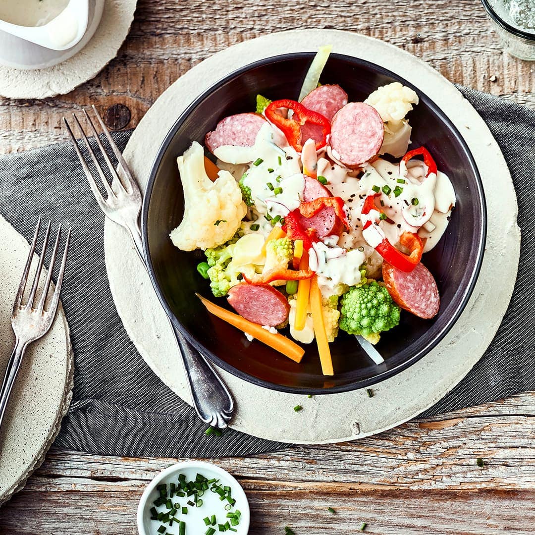 Bereiten Sie mit unserem Blumenkohlsalat-Rezept eine leichte Mahlzeit mit viel Gemüse, Cabanossi und frischem Dressing zu. Das perfekte Low-Carb-Gericht.