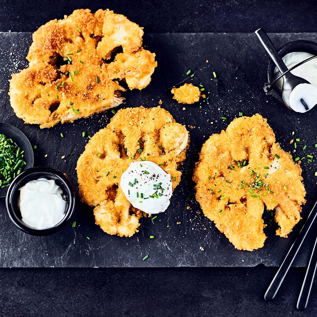Mit knuspriger Panade und selbstgemachtem Joghurt-Schmand-Dip schmecken diese Blumenkohl-Schnitzel sicherlich nicht nur Vegetariern richtig gut.