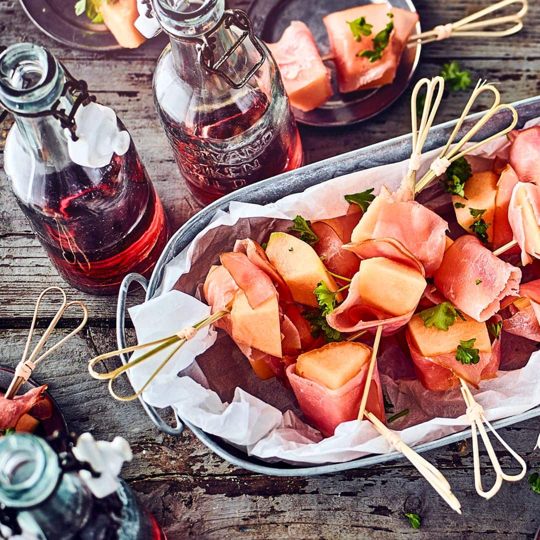 Ganz einfach aber ein leckerer Snack zum Grillabend oder auf dem Buffettisch: Saftige Honigmelone in Stücke geschnitten und mit Schinken umwickelt.