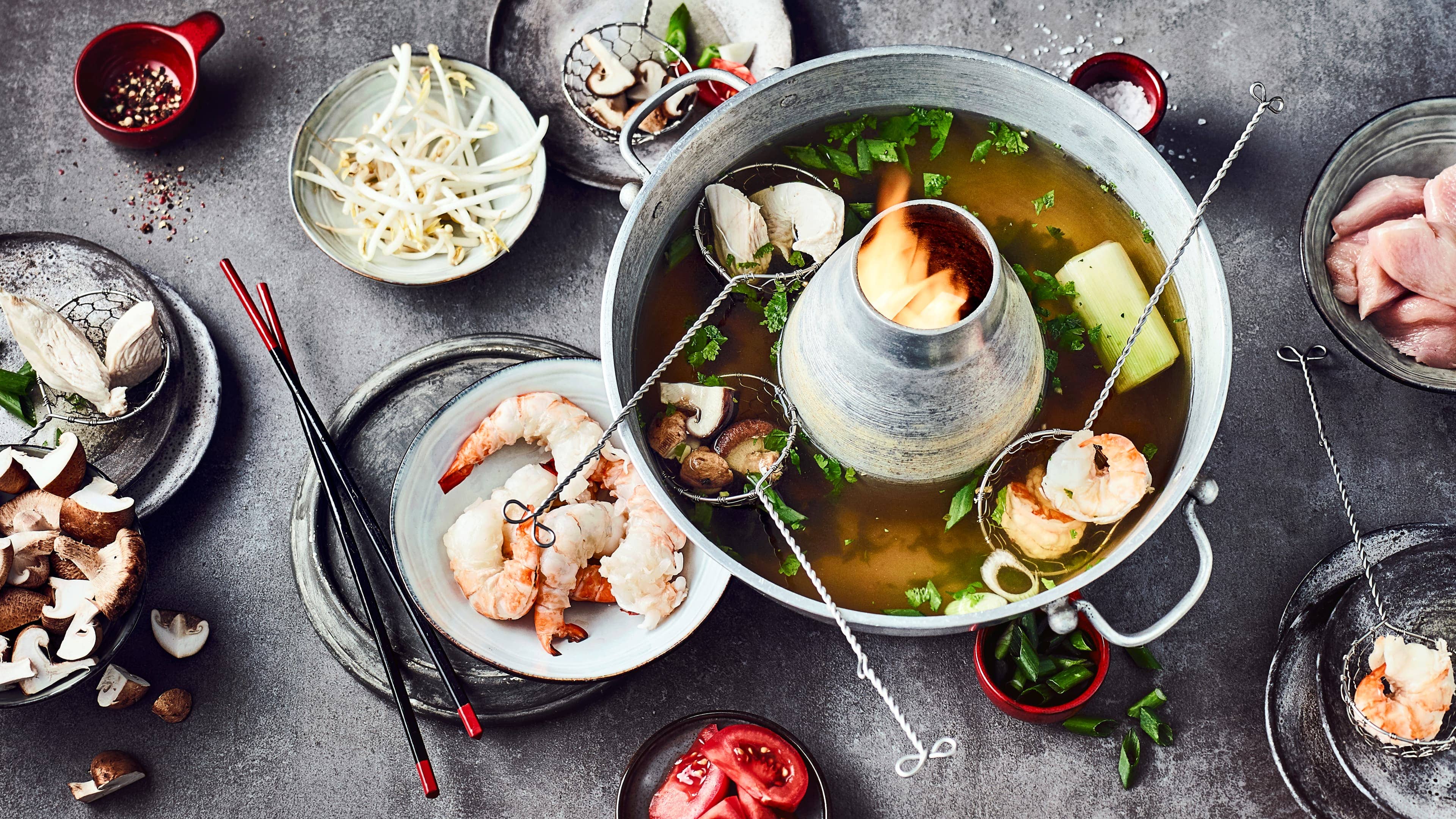 Mongolischer Feuertopf Ähnlich einer Fondue-Idee funktioniert ein mongolischer Feuertopf. Leckere, frische Zutaten die mit einem köstlichen Erdnuss-Chili-Dip genossen werden können.