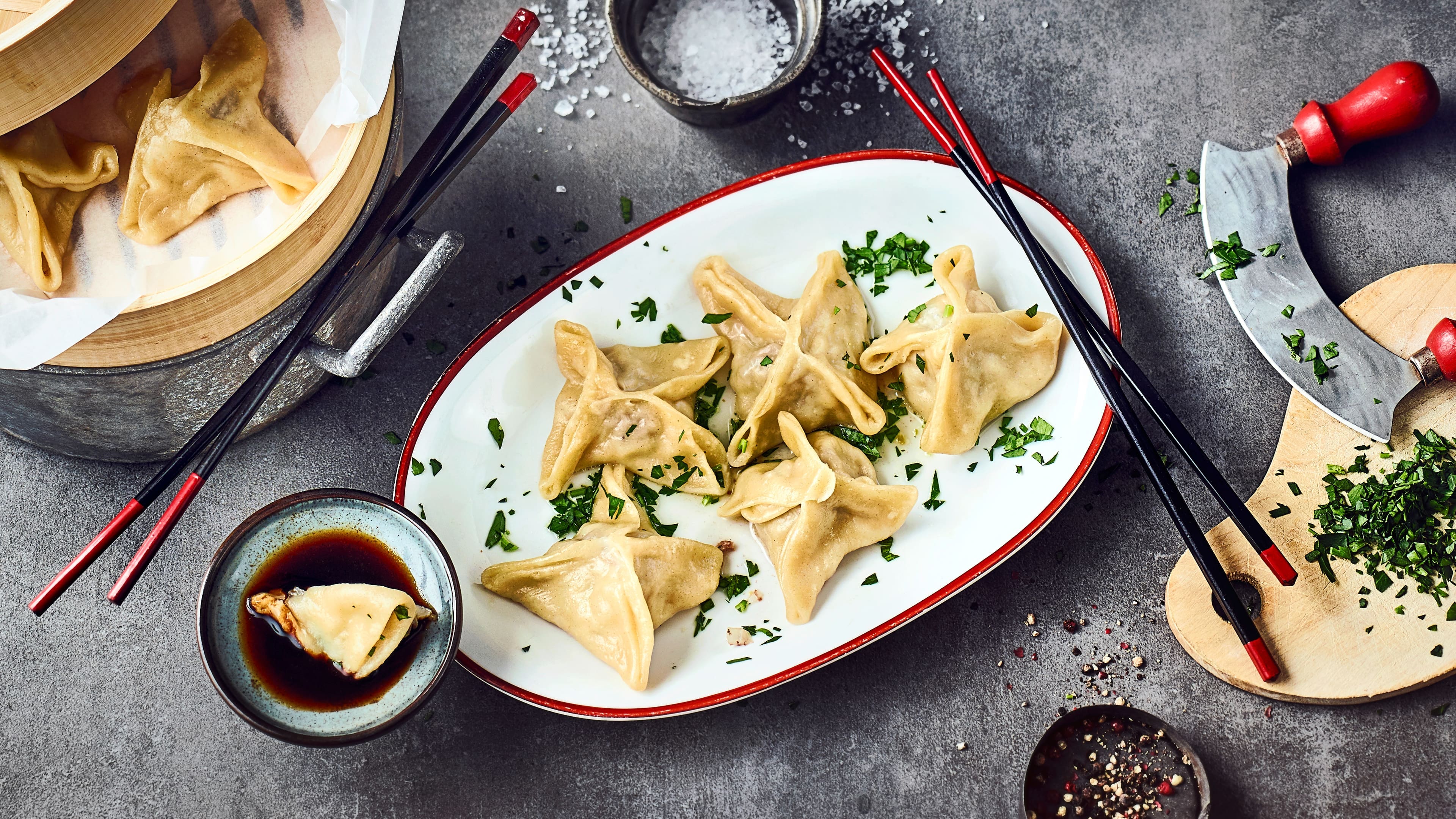 Mongolische Teigtaschen Die mit Hackfleisch und allerlei Gewürzen gefüllten Teigtaschen werden hier nicht frittiert sondern gedämpft und anschließend mit frischen Kräutern garniert serviert.