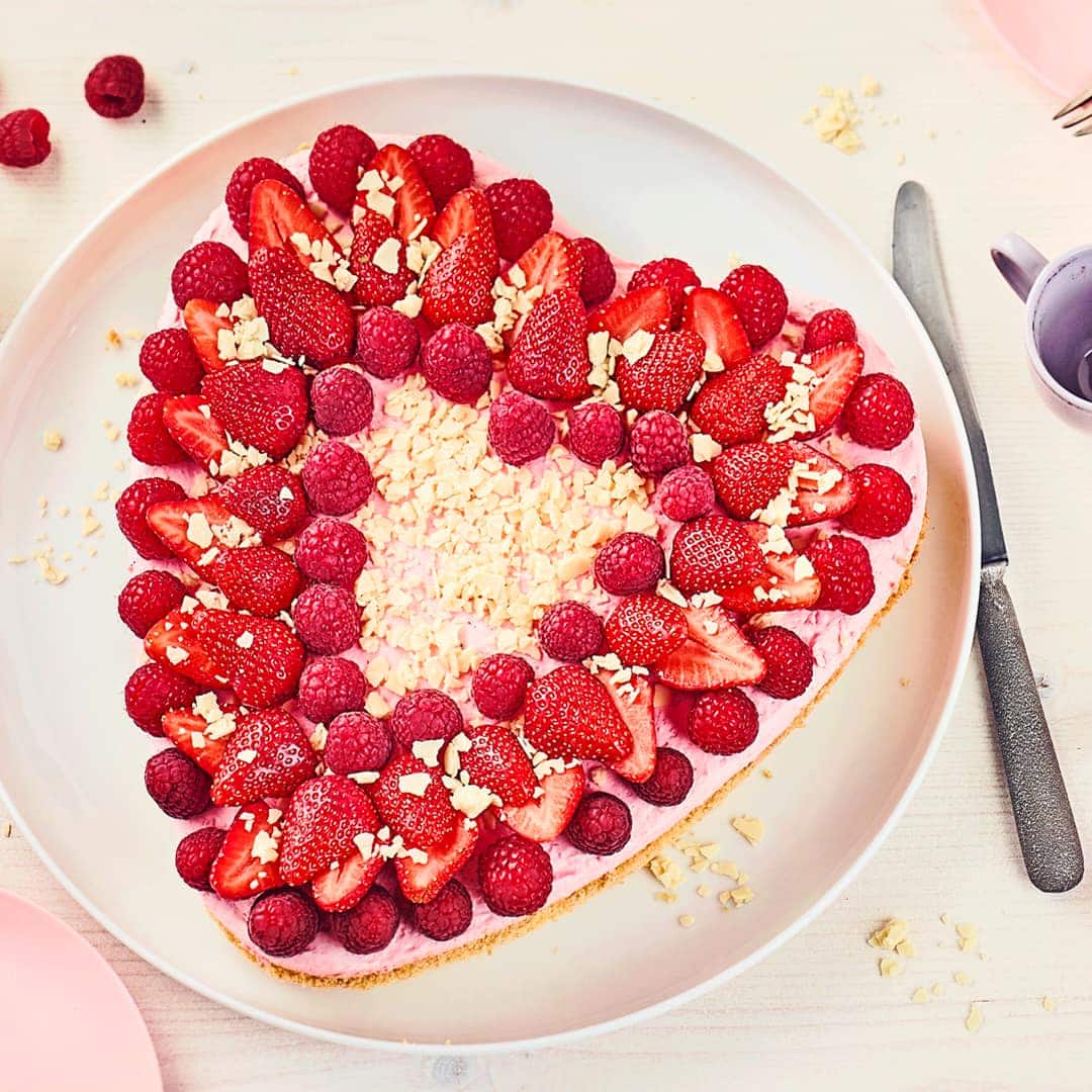 Luftiger Biskuit, gefüllt mit einer köstlichen Erdbeer-Vanillecreme mit Erdbeerlikör und anschließend mit Erdbeeren, Himbeeren und weißer Schokolade dekoriert.