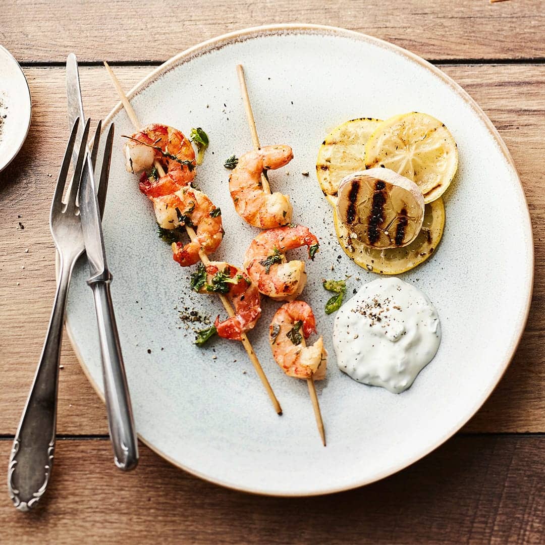 Eine leckere Spezialität vom Grill: Gegrillte Garnelenspieße mit Knoblauch und Zitrone und dazu ein selbstgemachter Joghurt-Mascarpone-Dip mit Basilikum und Minze.