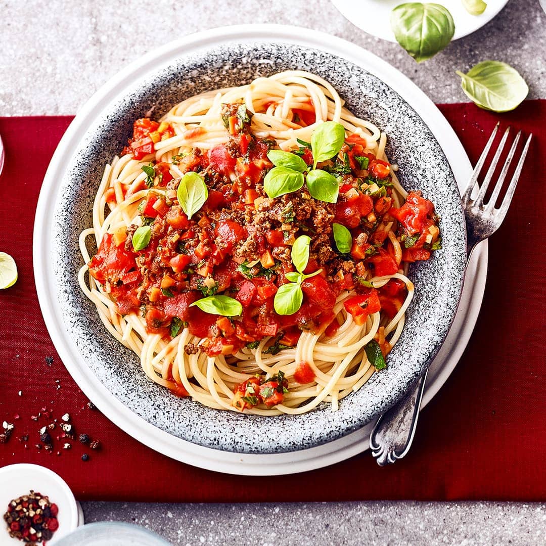 Probieren Sie unser Rezept für vegane Spaghetti bolognese einmal aus: Mit Lauch, Staudensellerie, Paprika, Tomaten, Soja-Hack und leckeren Kräutern – fertig in 45 Minuten!