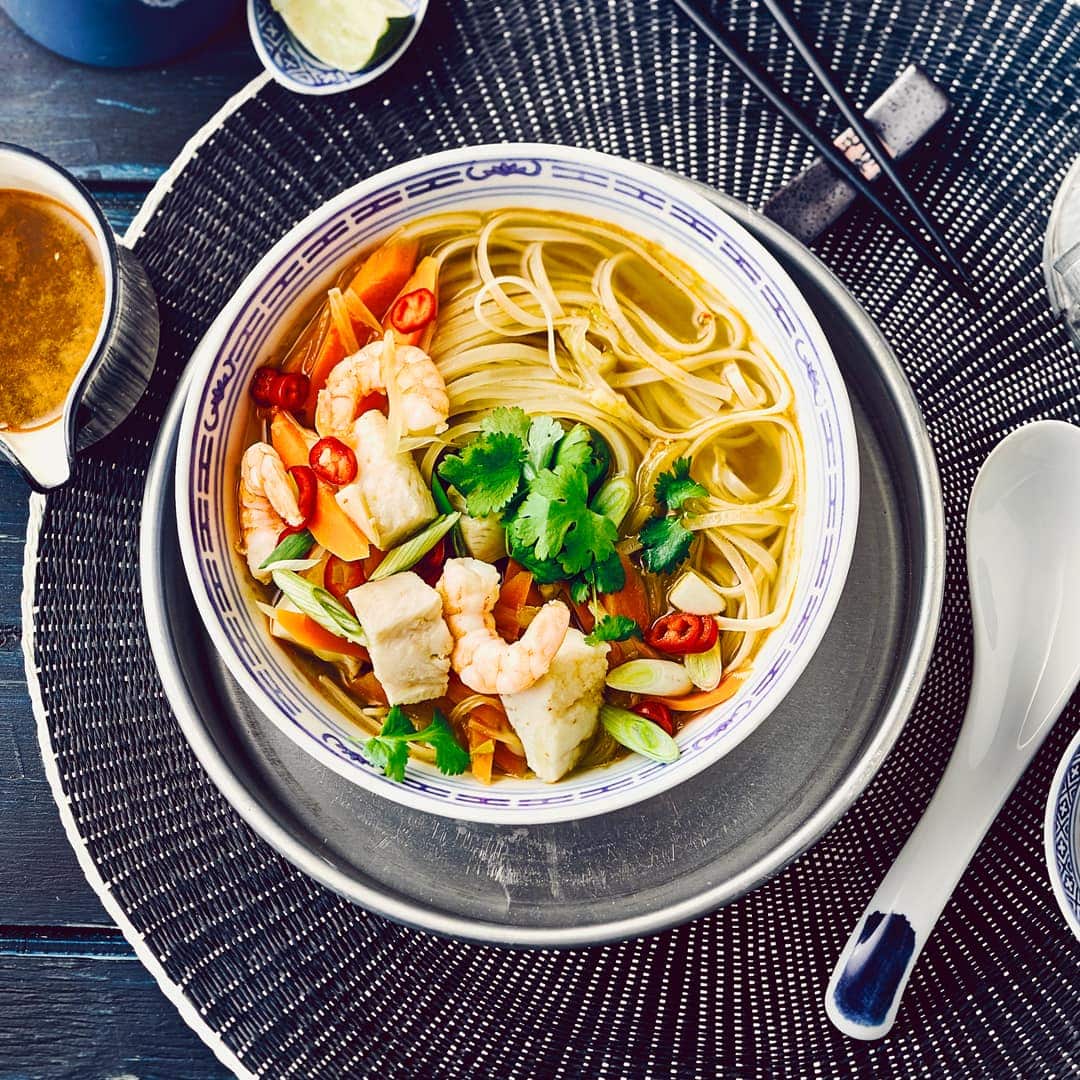 Dieses reichhaltige Gericht aus Vietnam wärmt von innen: Probieren Sie unsere Pho-Suppe mit Ingwer, Zimt, Anis und Pangasiusfilet, dazu Garnelen und Reisbandnudeln – würzig und lecker!