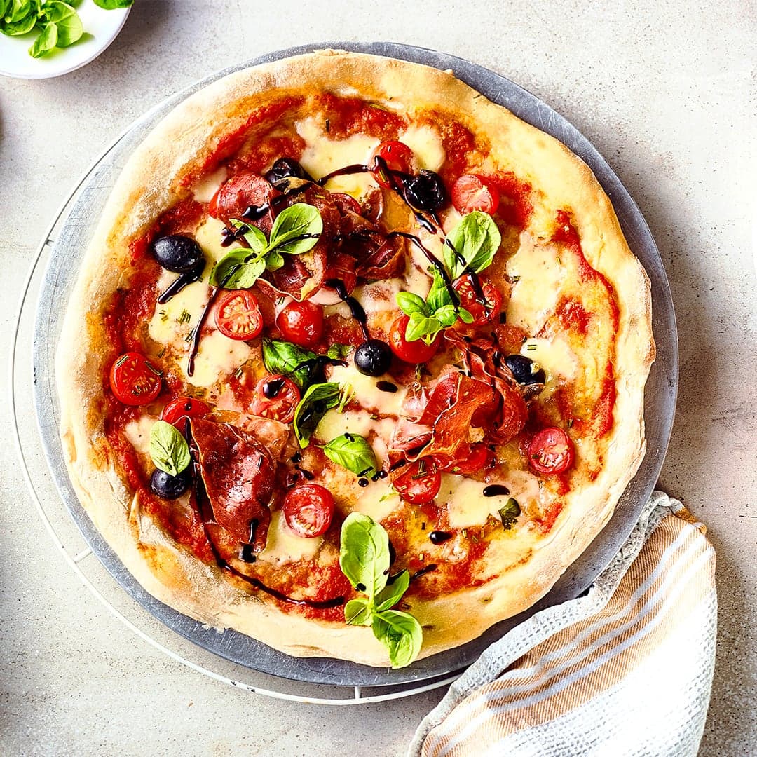 Pizza aus dem Ofen kann jeder – wir servieren die knusprige Spezialität vom Grill und belegen sie vorher mit Cherrytomaten, Parmaschinken und Mozzarella.