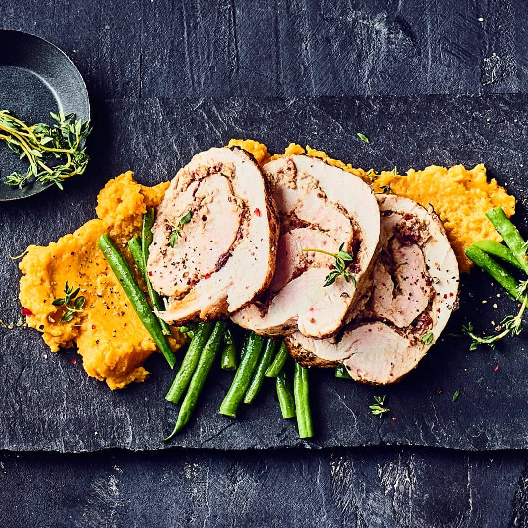 Sowohl die köstliche Walnuss-Frischkäse-Cranberry-Füllung als auch die Süßkartoffel- und Prinzessbohnen-Beilagen machen unser Rezept für einen Putenrollbraten besonders schmackhaft.