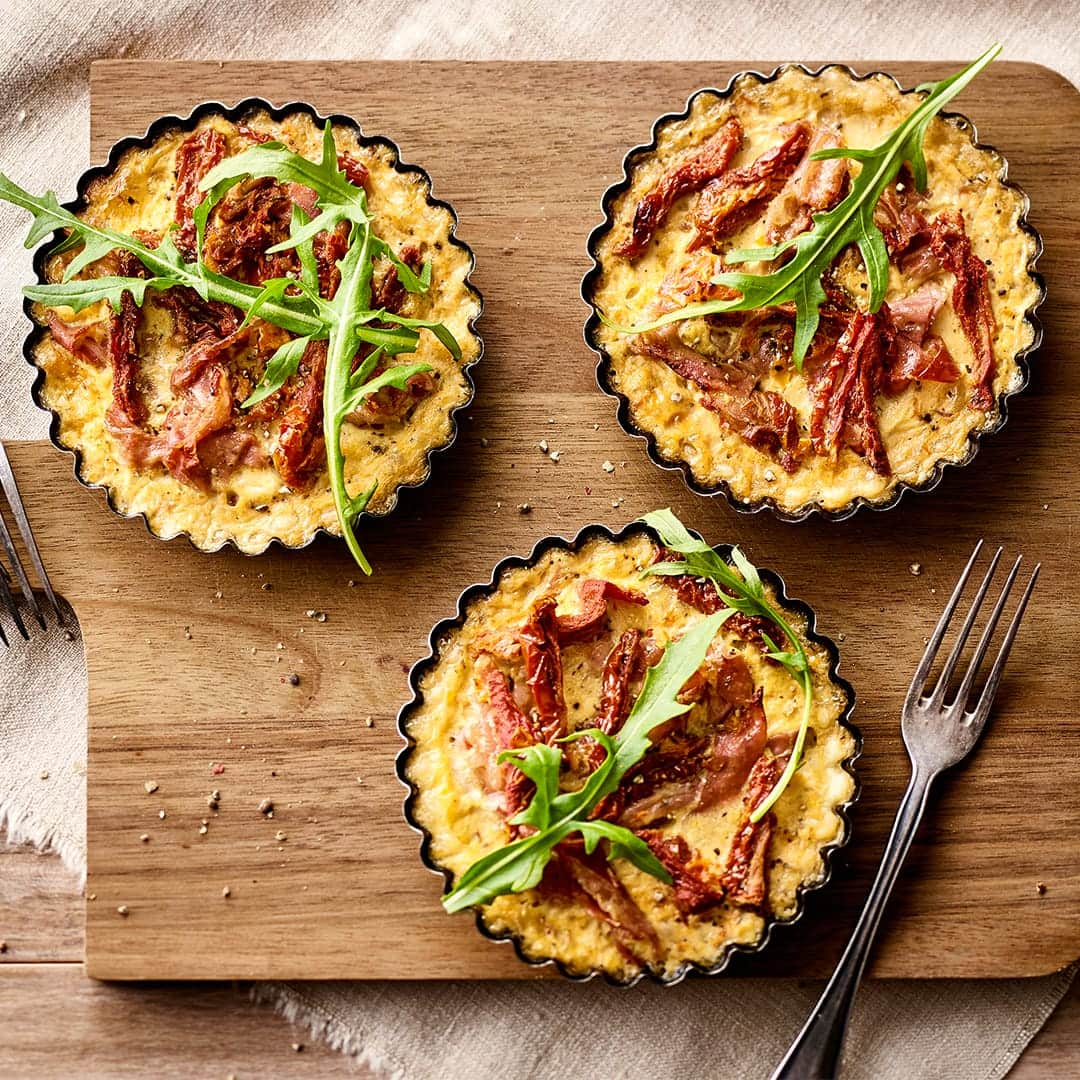 Unser Rezept für Mini-Quiche aus Mürbeteig gefüllt mit Parmaschinken, getrockneten Tomaten und Sahne eignet sich gut für jedes Buffet – gleich ausprobieren!