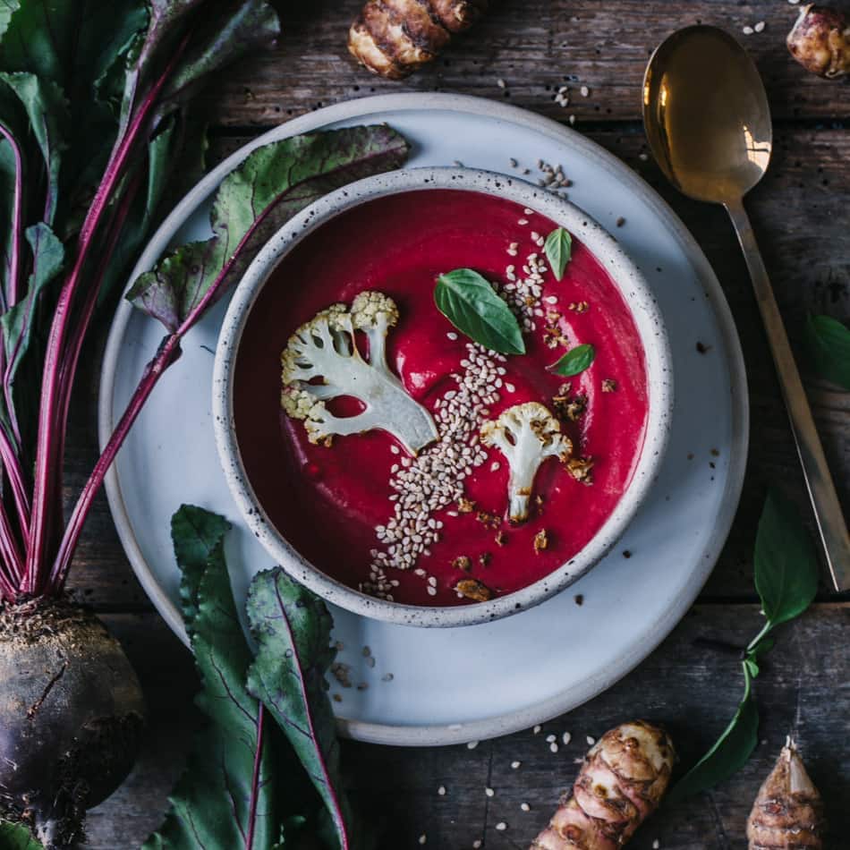 Rote-Bete-Topinambur-Suppe mit Kokosmilch, gerösteten Blumenkohlscheiben und Topinambur-Chips.