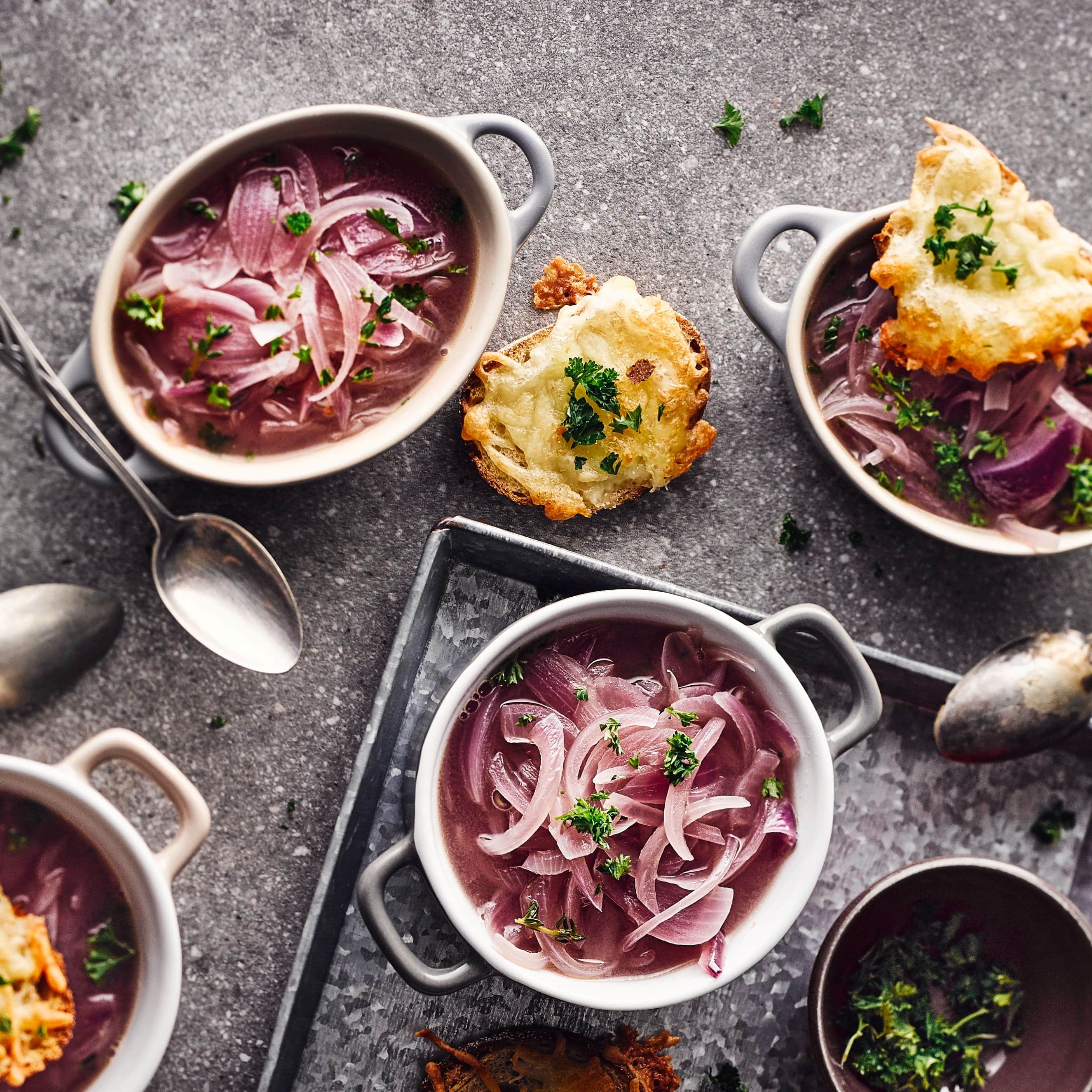 Unsere rote Zwiebelsuppe mit Butter, Lorbeer, Thymian, einem Schuss Weißwein und einer knusprigen Käsegratinhaube ist genau richtig, wenn Sie es deftig mögen – ideal für kalte Wintertage!