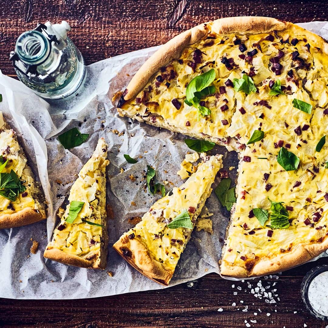 Mit Hefeteig, Kümmel und saurer Sahne: Klassischer schwäbischer Zwiebelkuchen frisch aus dem Ofen lässt Ihnen das Wasser im Mund zusammenlaufen.