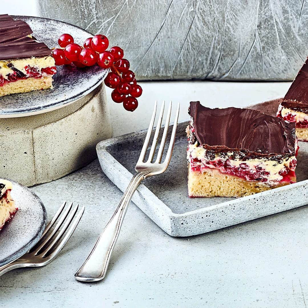 SchneewittchenkuchenIm Schneewittchenkuchen finden sattrote Früchte, dunkle Schokoladenglasur und helle Buttercreme zu einem wahren Geschmacksmärchen zusammen. Entdecken Sie den auch als Donauwelle bekannten Kuchenklassiker aus Ostdeutschland!