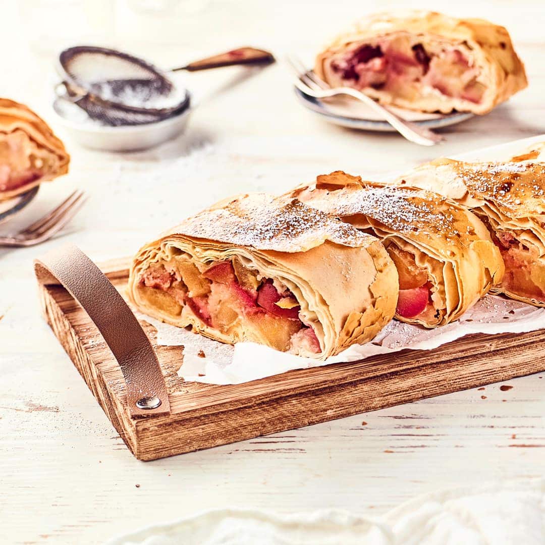 Aus saftigen Äpfeln und knusprigem Strudelteig wird eine köstliche traditionelle Leckerei: Ein Apfelstrudel! Backen Sie süße Füllung in knusprigem Teig!