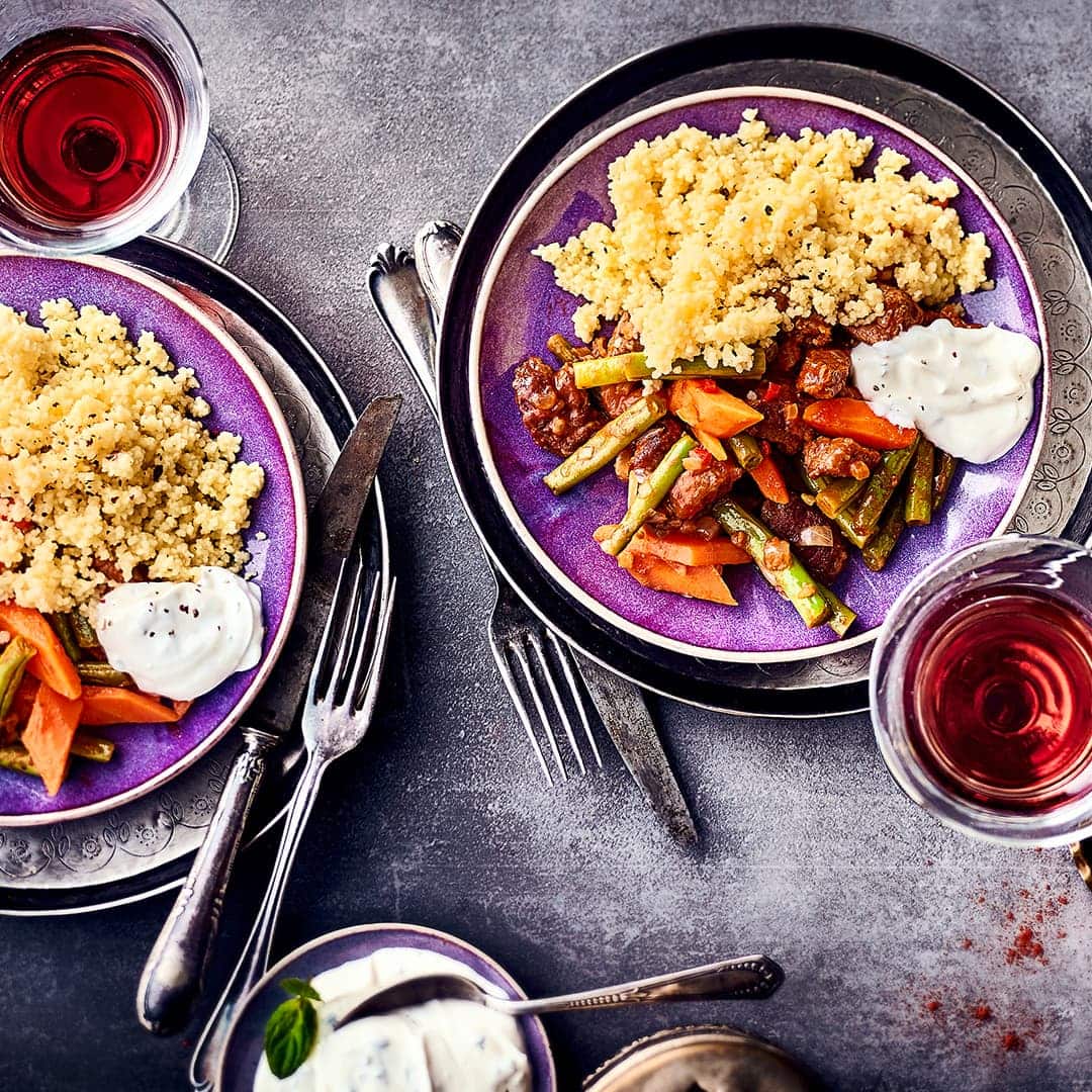 Aromatisches Lammfleisch, reichlich Gemüse, körniger Couscous und ein erfrischender Minze-Joghurt vereinen sich in unserem Lammgulasch-Rezept.