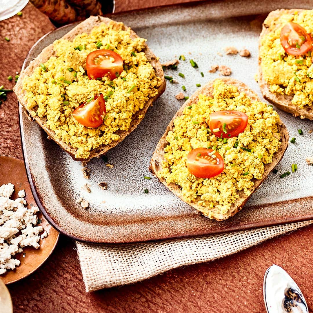 Sie möchten sich ein rein veganes Tofu-Frühstück zubereiten? Dann testen Sie unser Tofu-Rührei-Rezept mit Kurkuma, Tomaten und Mandelmus!