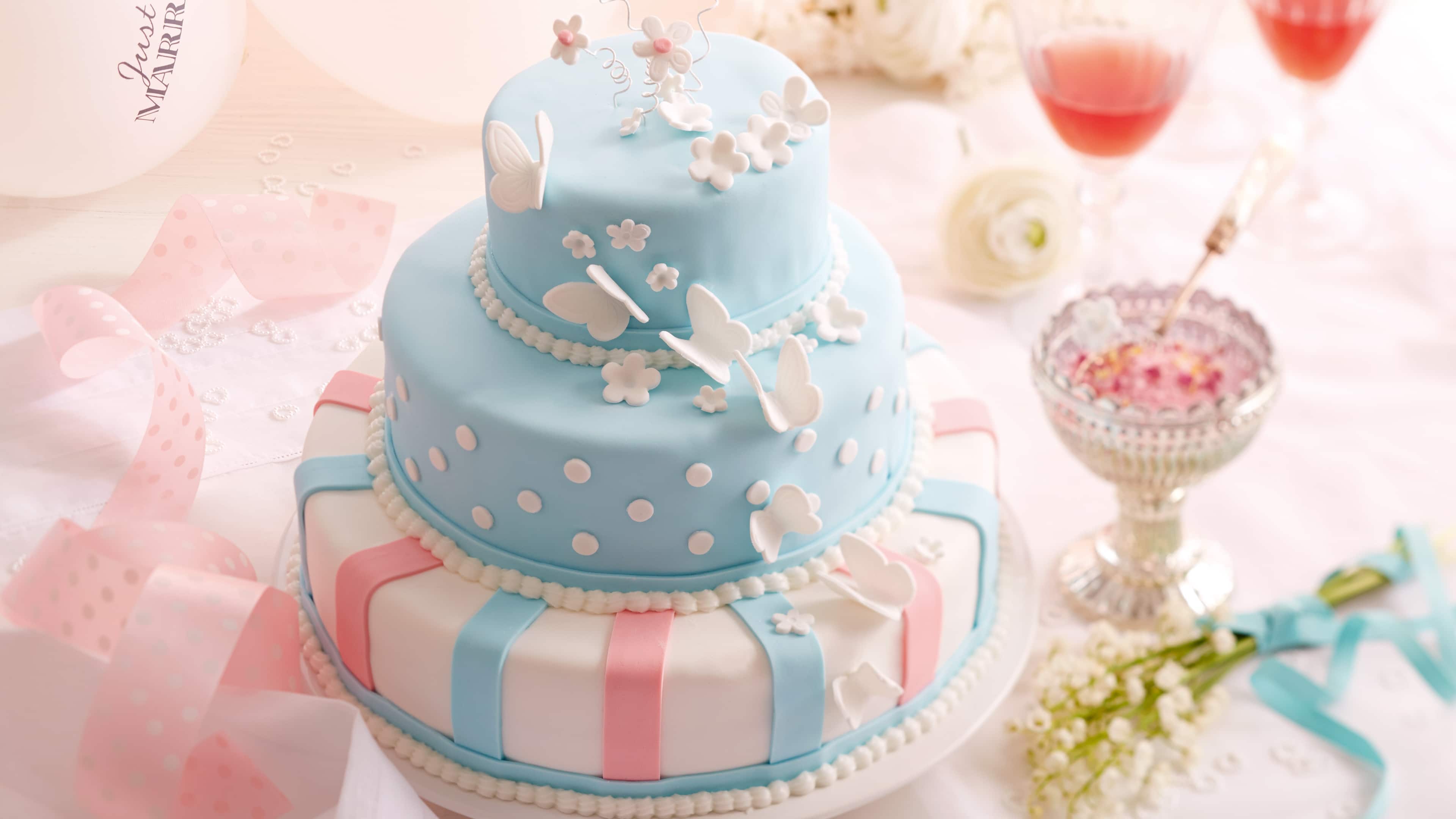 Hochzeitstorte Dreistöckige Hochzeitstorte aus Schokoladenbiskuit, mit Vanillebuttercreme gefüllt und mit Fondant dekoriert.