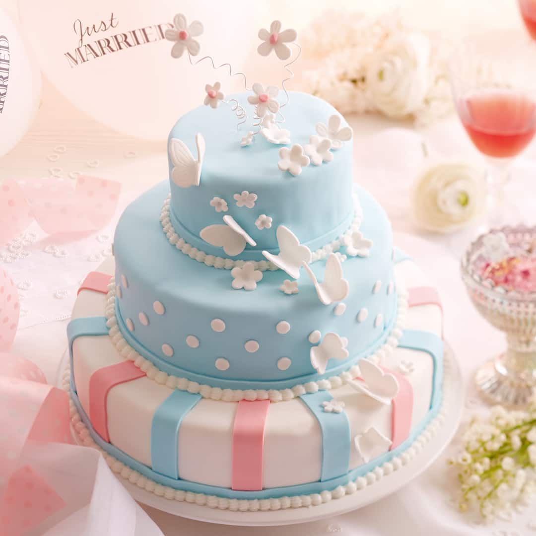 Dreistöckige Hochzeitstorte aus Schokoladenbiskuit, mit Vanillebuttercreme gefüllt und mit Fondant dekoriert.