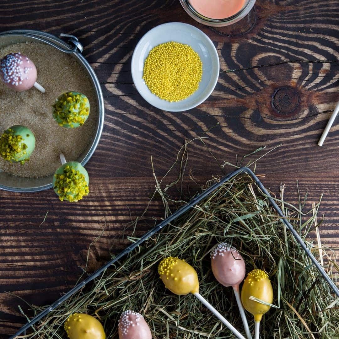 Unser Rezept für Oster-Cake-Pops zeigt Ihnen genau, wie Sie bunte Kucheneier am Stiel herstellen. Die Verzierung besteht aus weißer Schokolade.