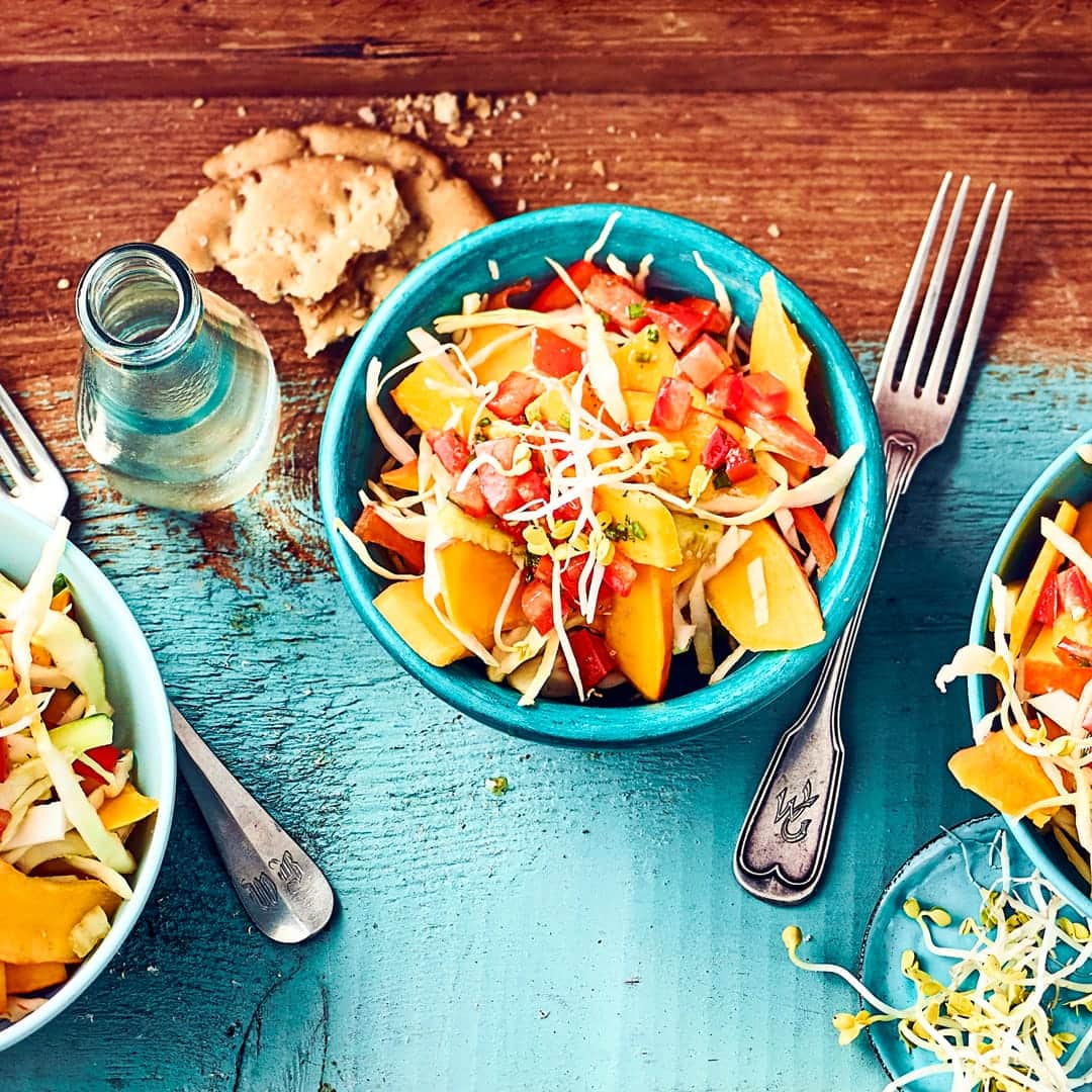 Knackiger Rohkostsalat mit Kürbis, Gurken, Tomaten und Weißkohl, angemacht mit einer selbstgemachten Tomatenvinaigrette und Radieschensprossen.