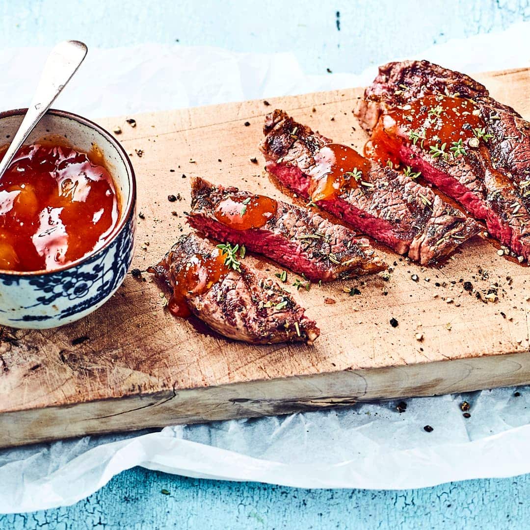 Probieren Sie unser Rezept für gegrillte Rindersteaks einmal aus: Mariniert in Öl, Rosmarin und Thymian und mit gebratenen Zwiebeln und Cocktailtomaten!