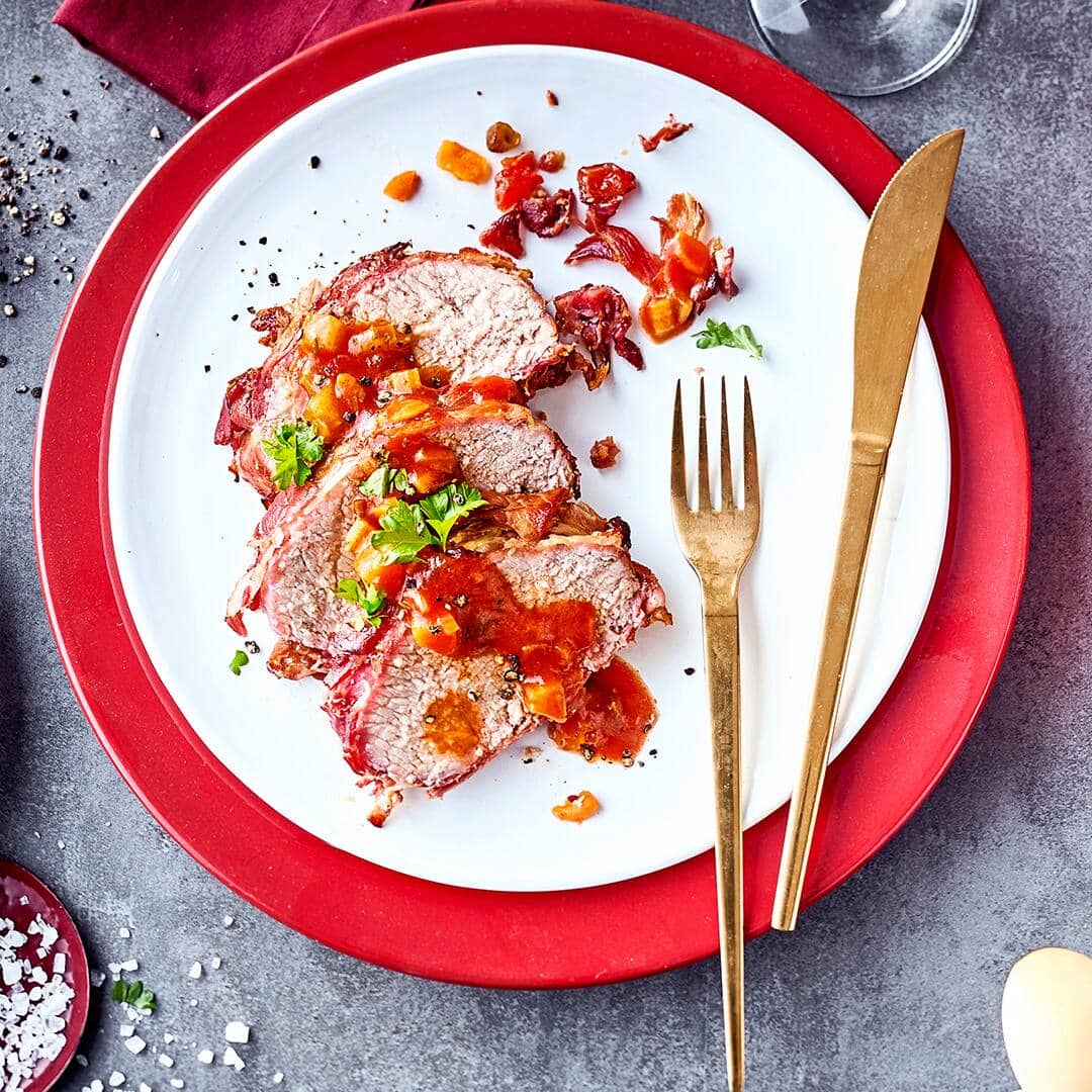 Mediterranes Fleischgericht: Probieren Sie unseren gebratenen Kalbsrücken mit Schinken in feiner Gemüsesoße mit Karotte, Sellerie und Tomaten!