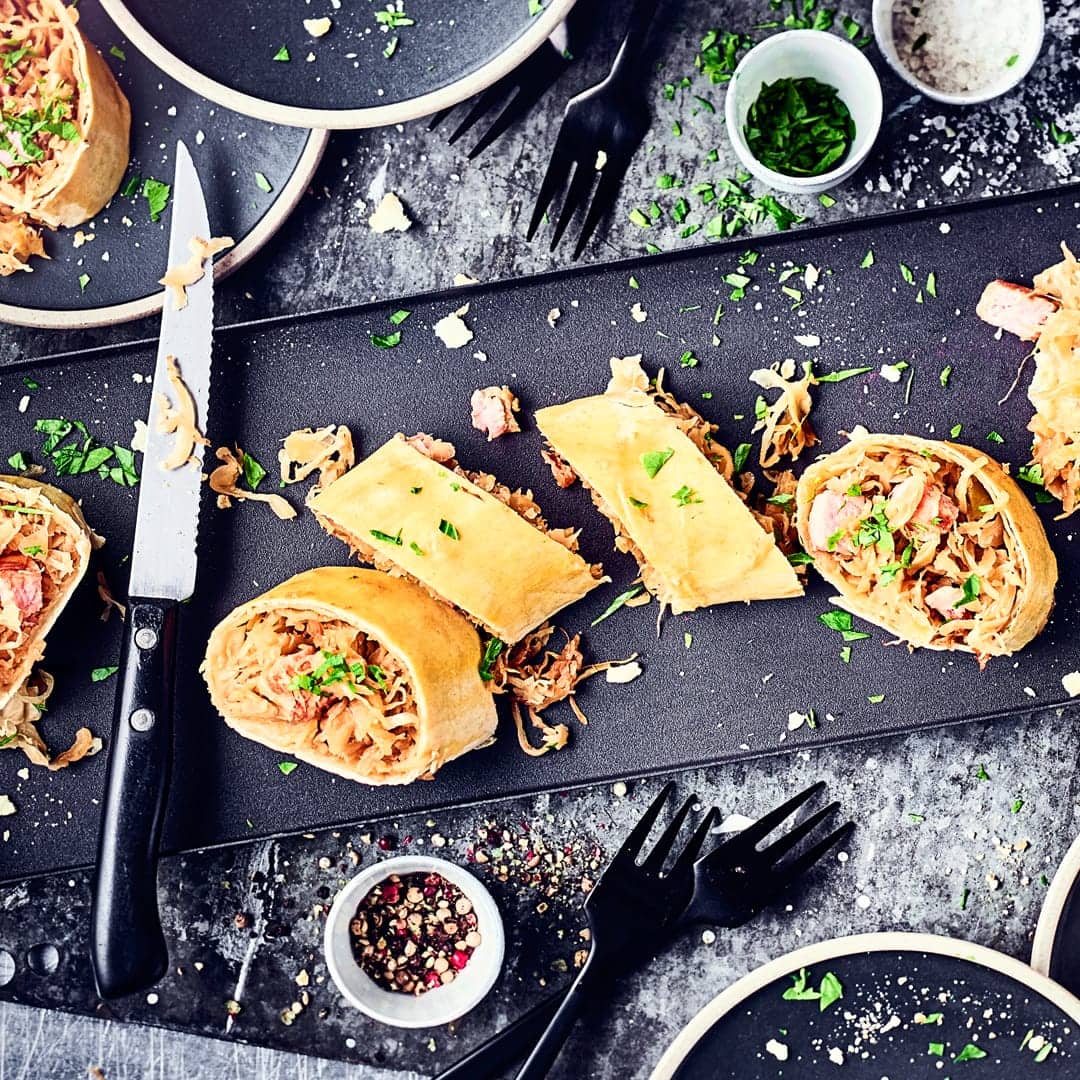 Unser Tipp für ein deftiges Wintergericht: Probieren Sie unseren selbst gemachten, herzhaften Strudel gefüllt mit Sauerkraut, saftigem Kassler und Möhren!