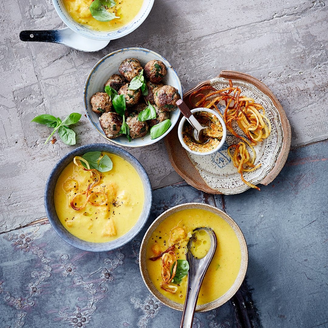 Vor allem im Herbst ein Genuss – Kürbissuppe. Eine tolle Kombination, die Familie und Gäste beeindruckt ist unsere cremige Kürbis-Parmesansuppe mit Hackbällchen, Kartoffelspaghetti und rotem Paprika-Pesto.
