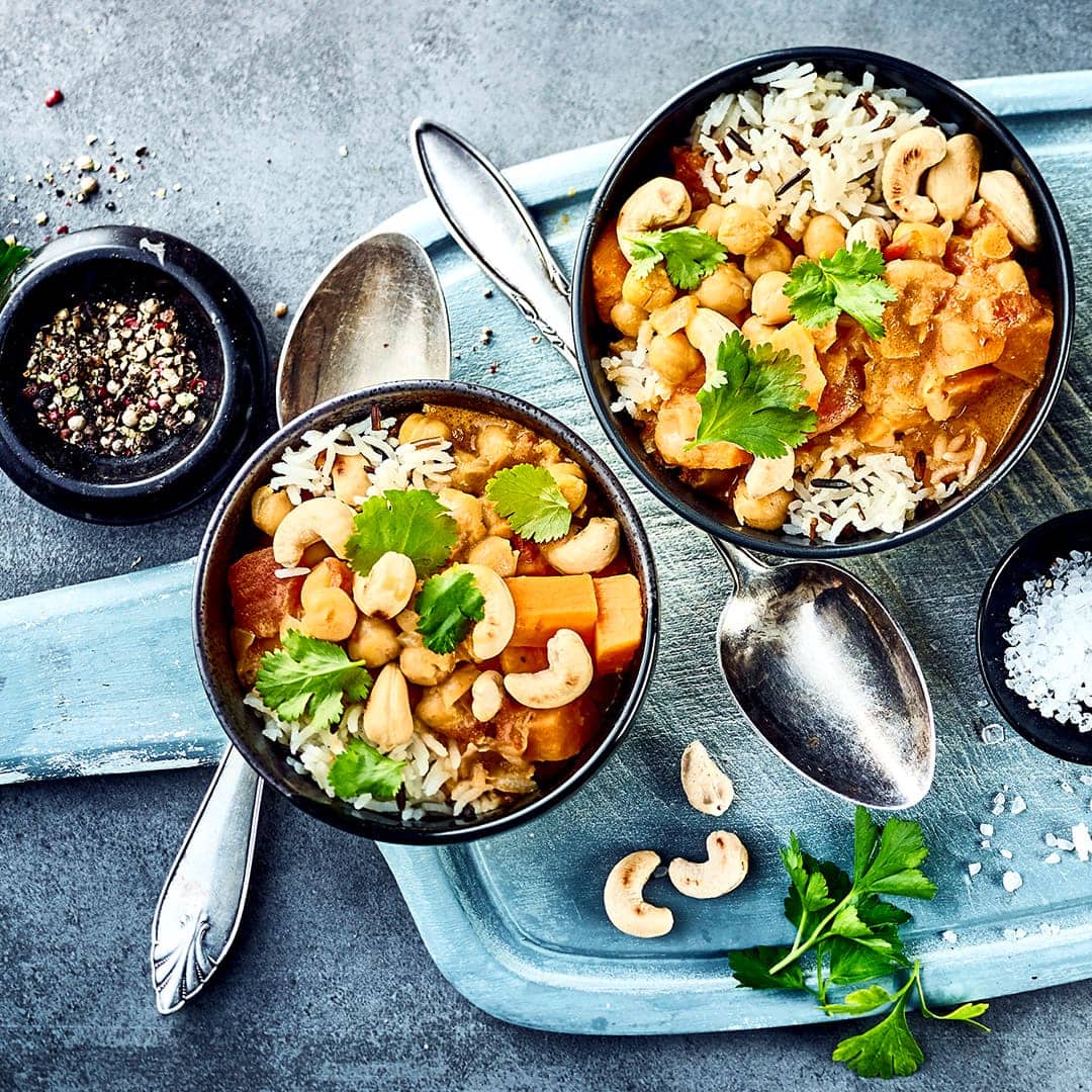 Schnell und einfach zubereitet und dazu köstlich cremig ist unser Kichererbsencurry mit Kokosmilch, Blattspinat, Süßkartoffel und Cashewkernen.