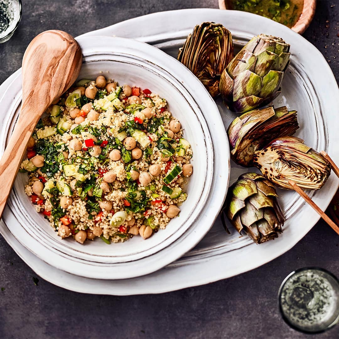 Probieren Sie unser Rezept für einen vegetarischen Kichererbsen-Couscous-Salat einmal aus: Mit Paprika, Gurke und einer Honig-Zitronen-Kümmel-Vinaigrette!