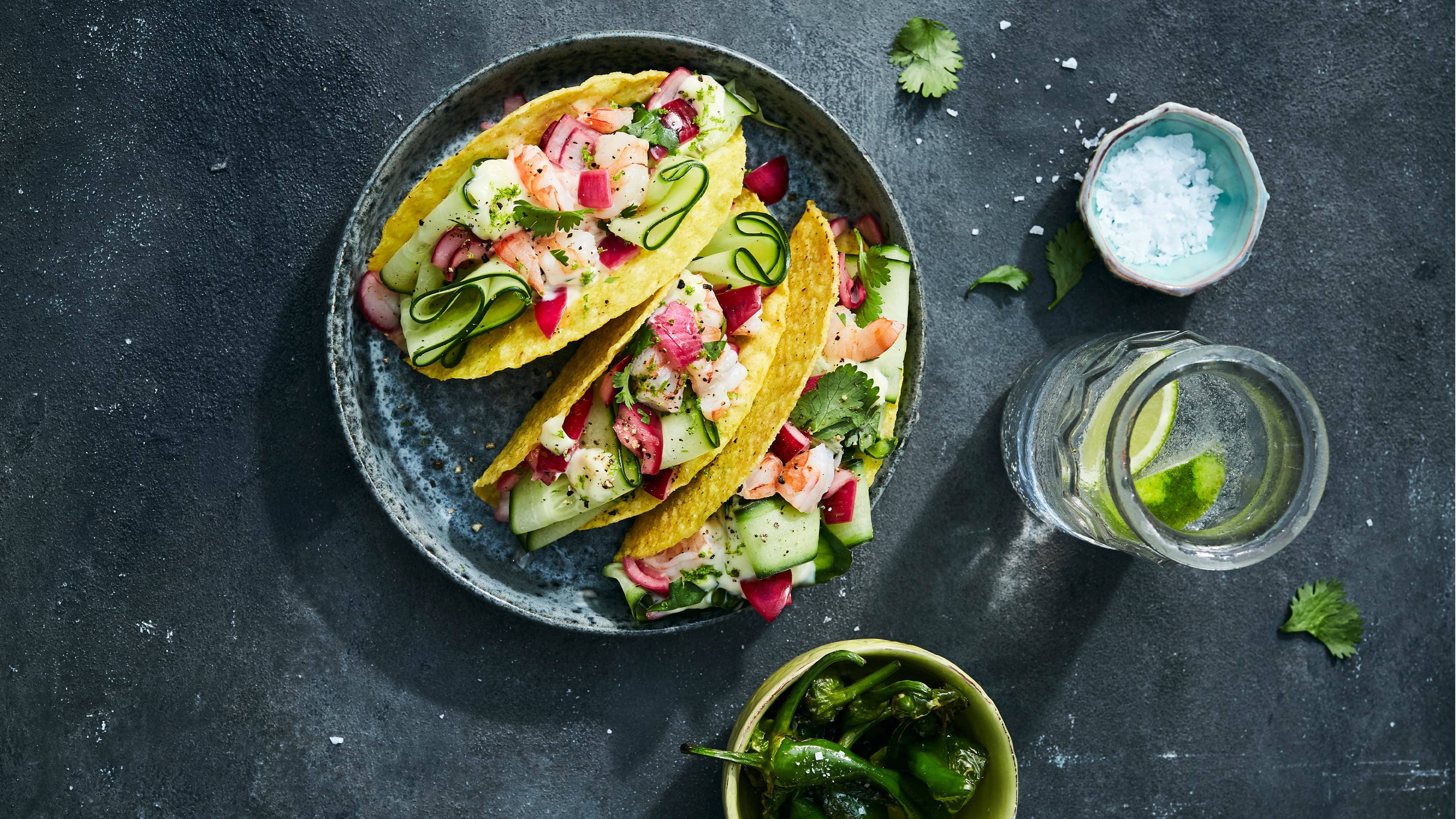 Taco-Shells mit Gurken und Garnelen Tacos einmal anders befüllt: Probieren Sie doch einmal unsere vegetarische Variante und bieten Gurken, Garnelen, Koriander und selbstgemachte Mayonnaise dazu an.