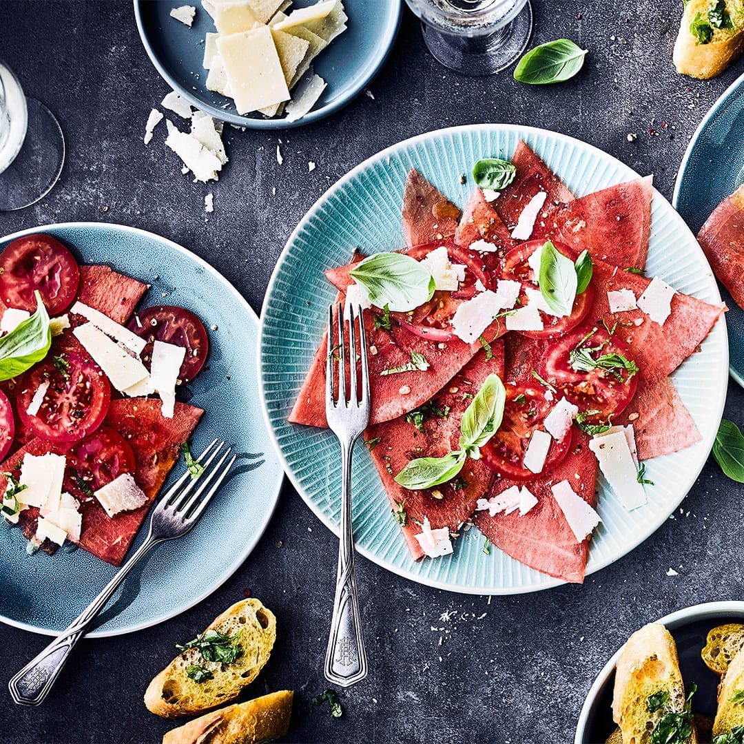 Holen Sie sich die Aromen Italiens in Ihre Küche und das ganz ohne Fleisch! Unser Tomaten-Melonen-Carpaccio ist der perfekte Snack für Ihre Party.