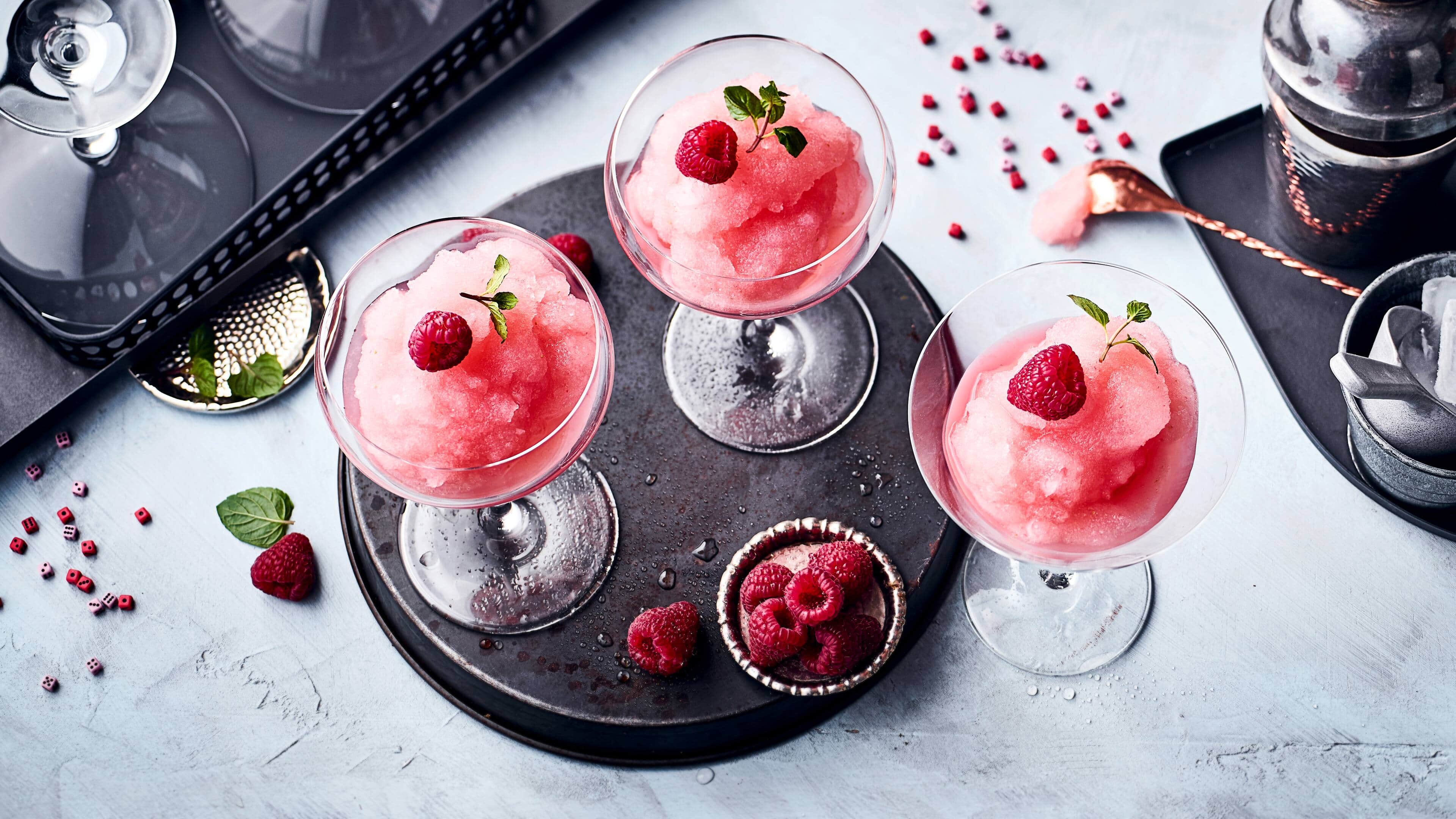 Frosé Definitiv ein Kandidat für den Sommerdrink des Jahres: Eiskalter Frosé aus gefrorenem Roséwein, etwas Zitrone, Zucker, Himbeere und Minze.