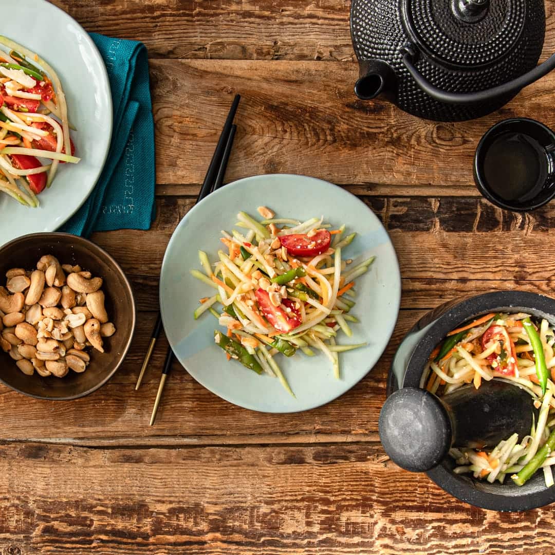 Bei Som Tam handelt es sich um einen scharfen Salat aus gestampfter grüner Papaya, Karotten, Bohnen und Nüssen, der mit getrockneten Shrimps garniert wird.
