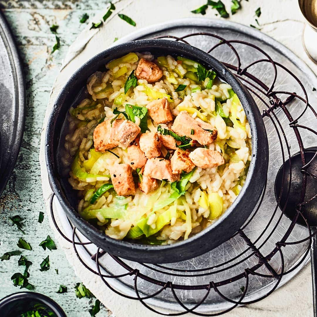 Probieren Sie unser Rezept für ein Risotto mit Parmesan und Lauch an gebratenen Wildlachswürfeln in Weißweinsoße einmal aus – pikant und lecker!